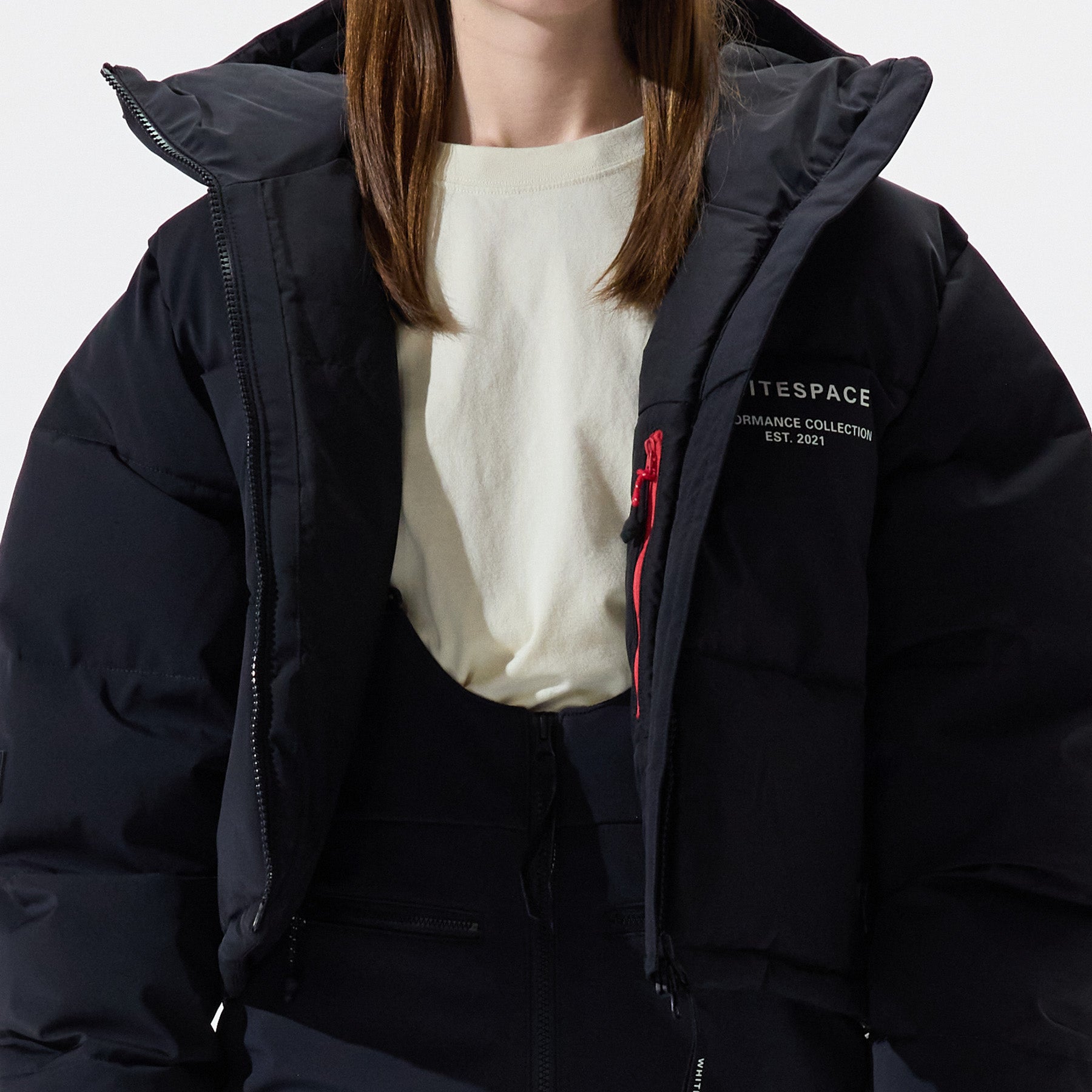Model wearing Cropped Puffer Jacket in black over a white shirt on a white background.