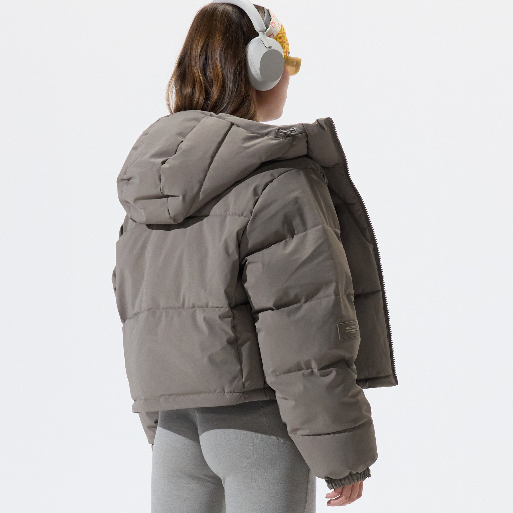 Model wearing Cropped Puffer Jacket in Falcon colorway, shown from the back, on a white background.