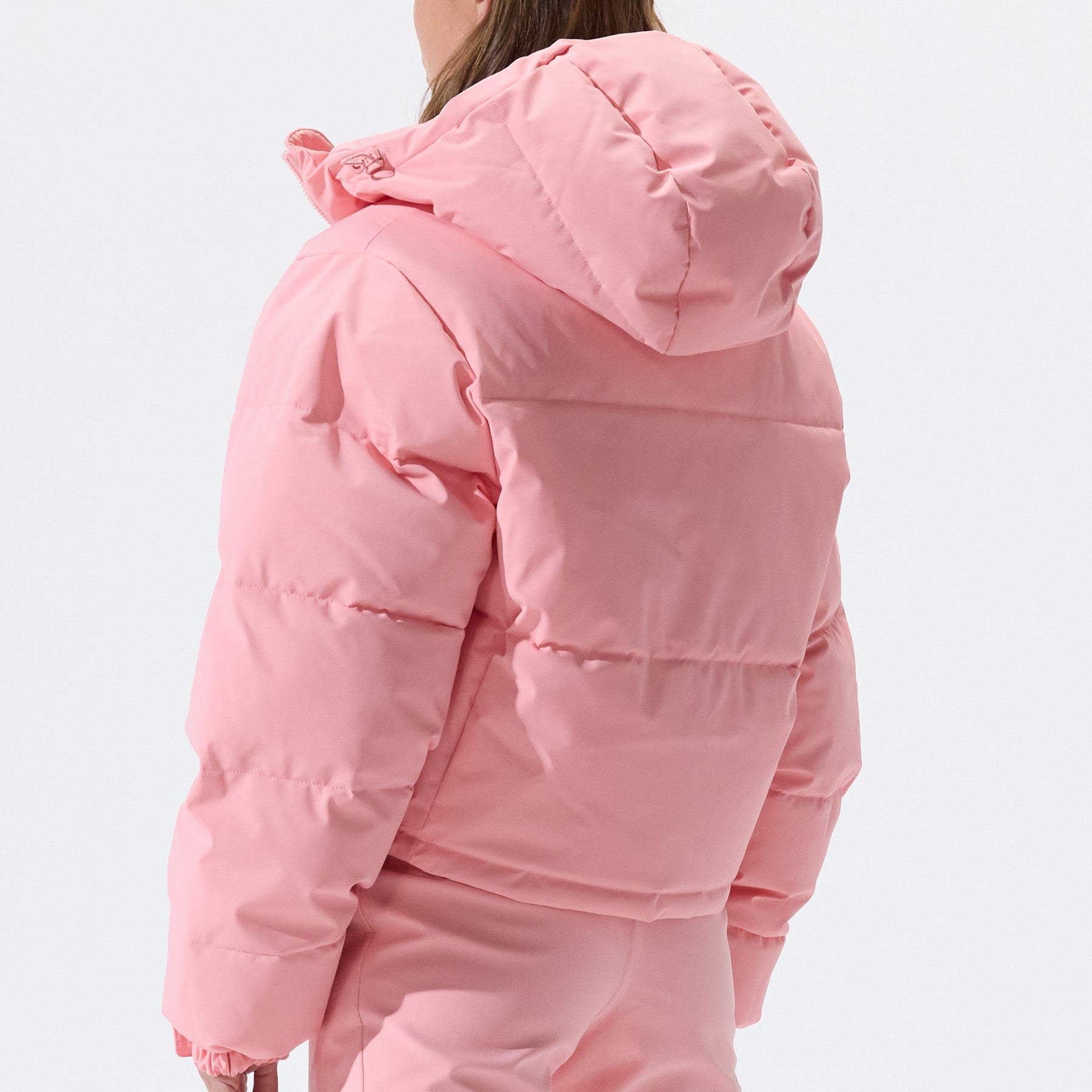 Model wearing Cropped Puffer Jacket in Pink Icing colorway shown from the back.