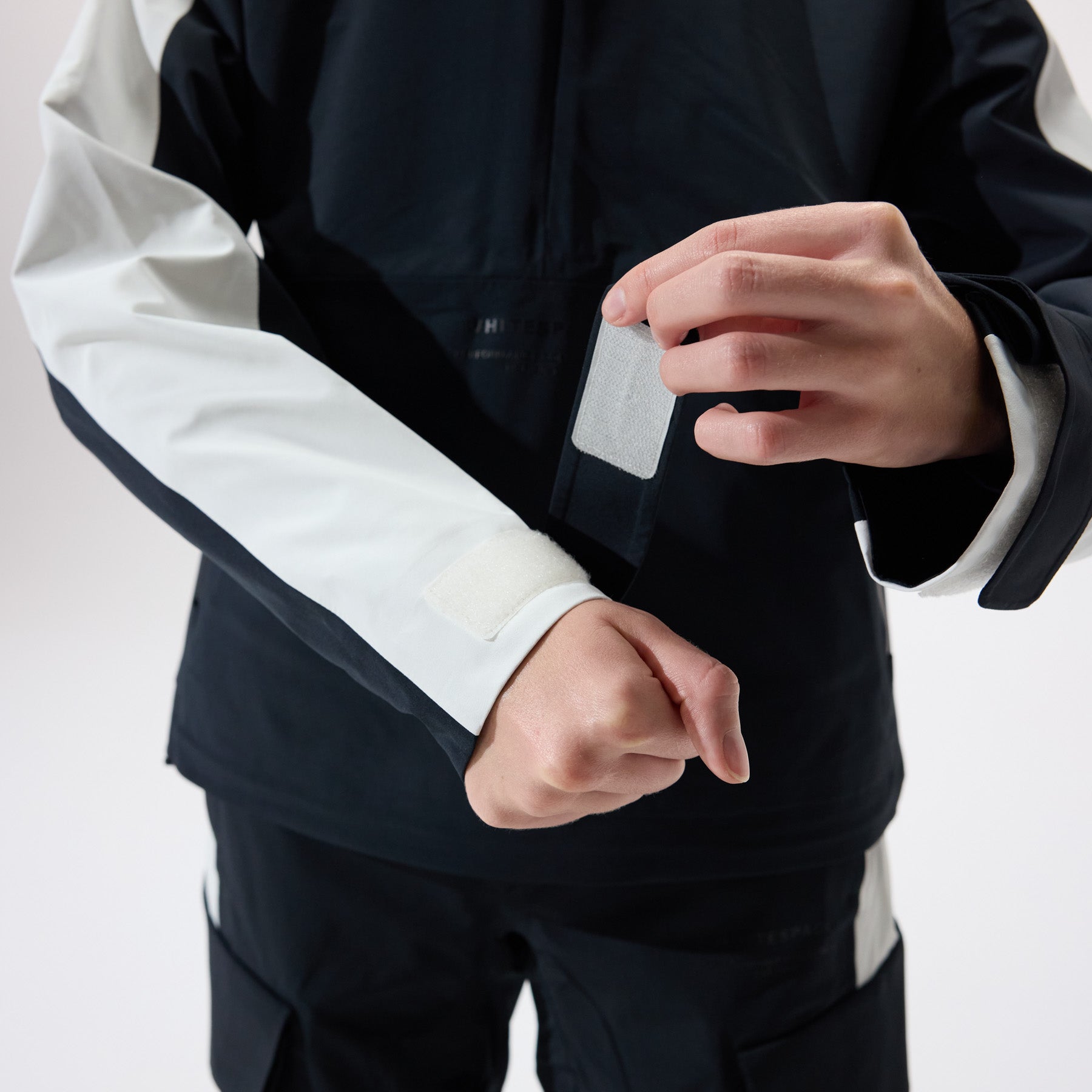 Model wearing a black and white jacket on a white background