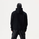 Model, from the back, wearing black Whitespace Block Hoodie and a black balaclava on a white background