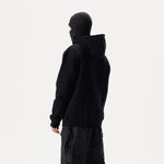 Model, from the back, wearing black Whitespace Block Hoodie and a black balaclava on a white background.