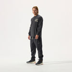 Model wearing Whitespace Sports Long Sleeved Tee in Phantom and coordinating black pants, on a white background.