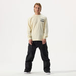 Model wearing Whitespace Sports Long Sleeved Tee in bone and black pants on a white background.