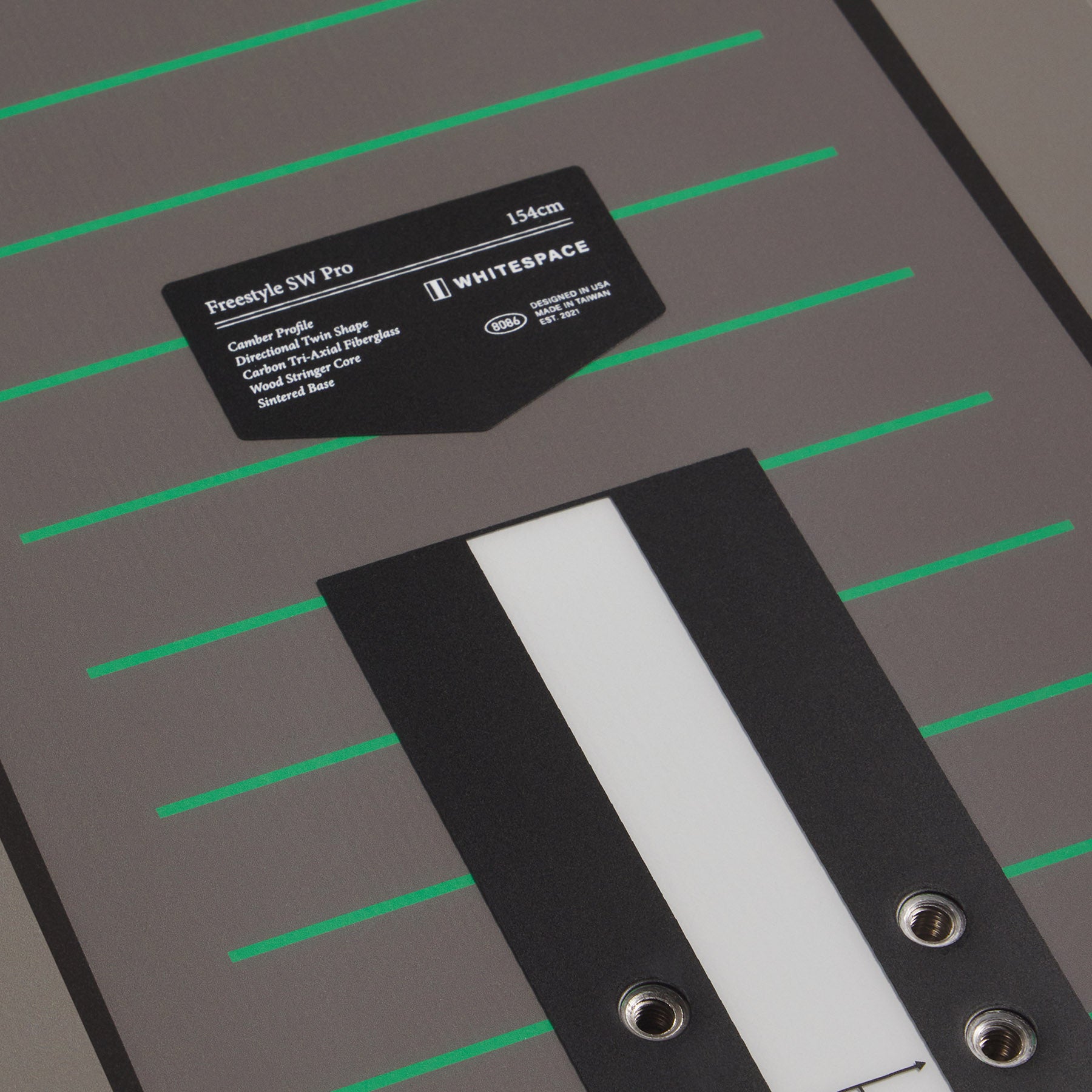 Grey Freestyle SW Pro snowboard deck with a label on a grey background