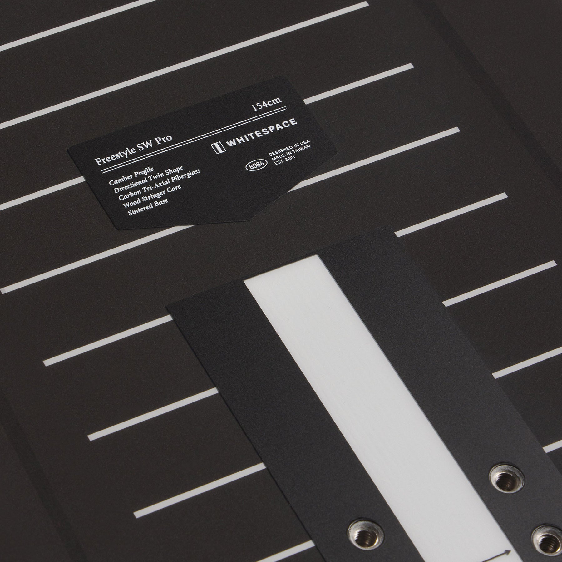 Black Freestyle SW Pro snowboard deck with a label on a black background