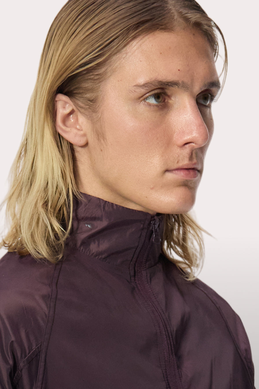 Model wearing the WHITESPACE Windbreaker Jacket in the color fudge.