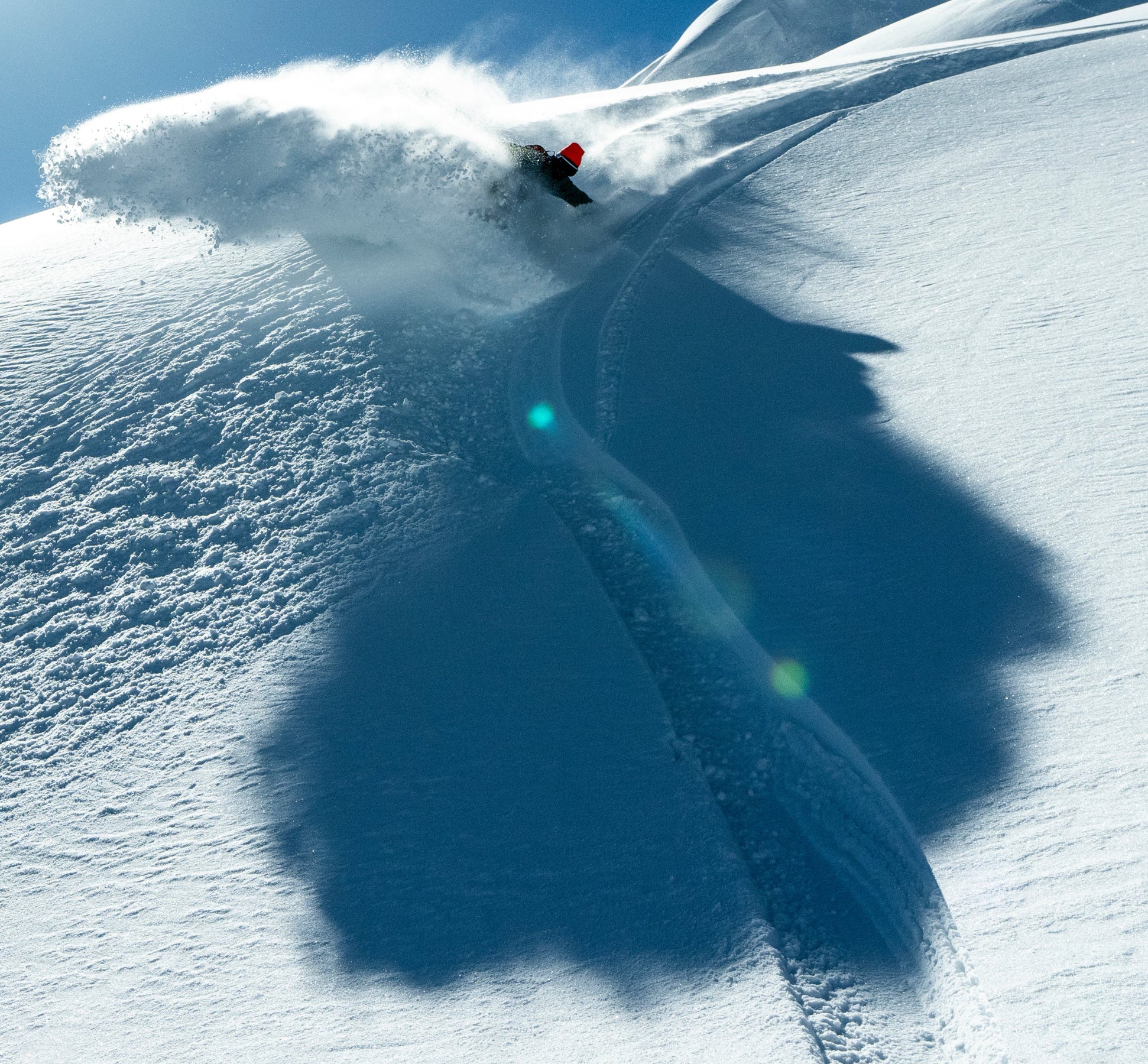 Pros snowboarder on the WHITESPACE Icona slashing through powder snow.