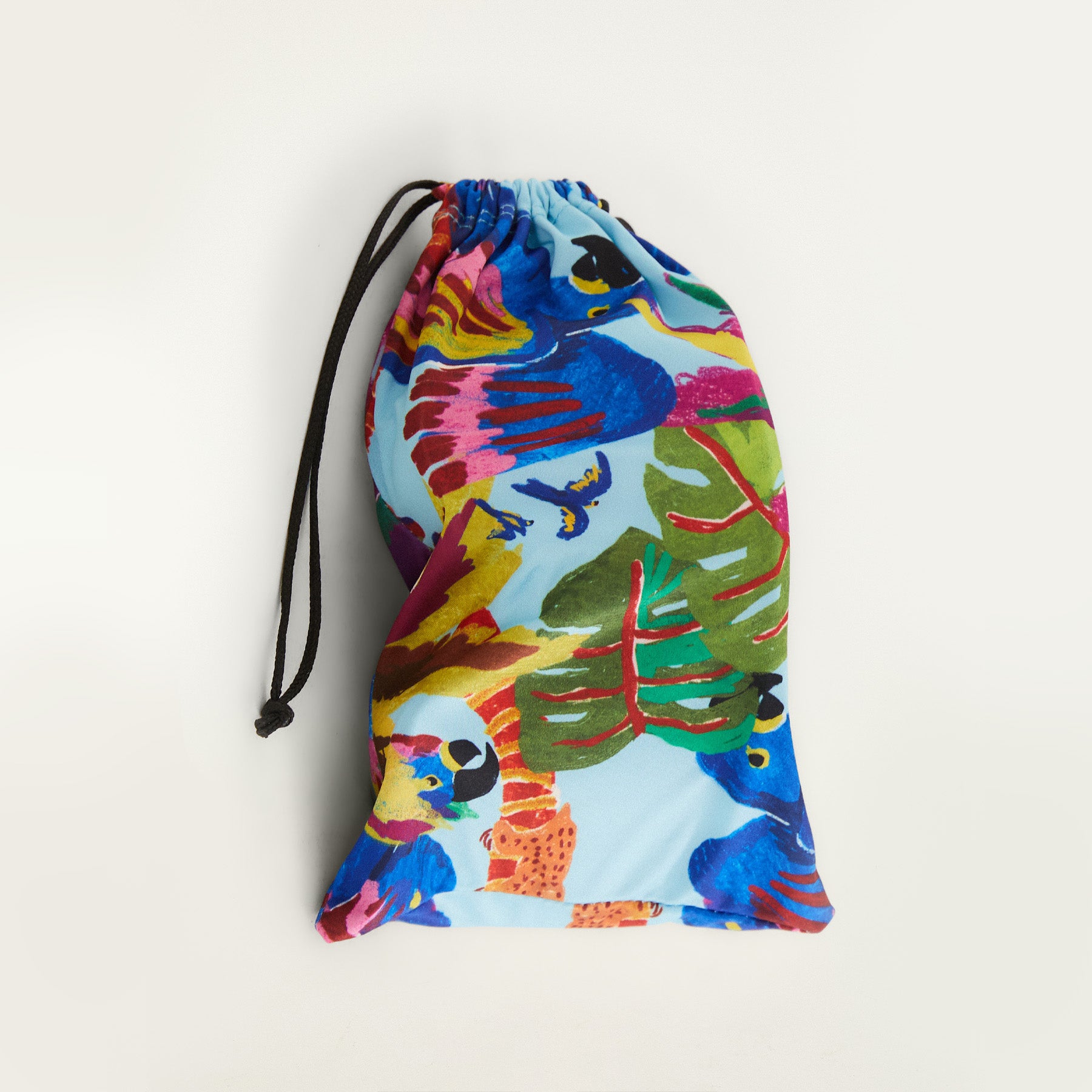 Colorful drawstring bag with a tropical leaf and macaw pattern on a white background