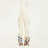 Flat lay of Farm Rio Lucy floral riding bib pants, cream colored bibs with orange and blue floral designs around the bottom of the legs and up the sides to the waist.