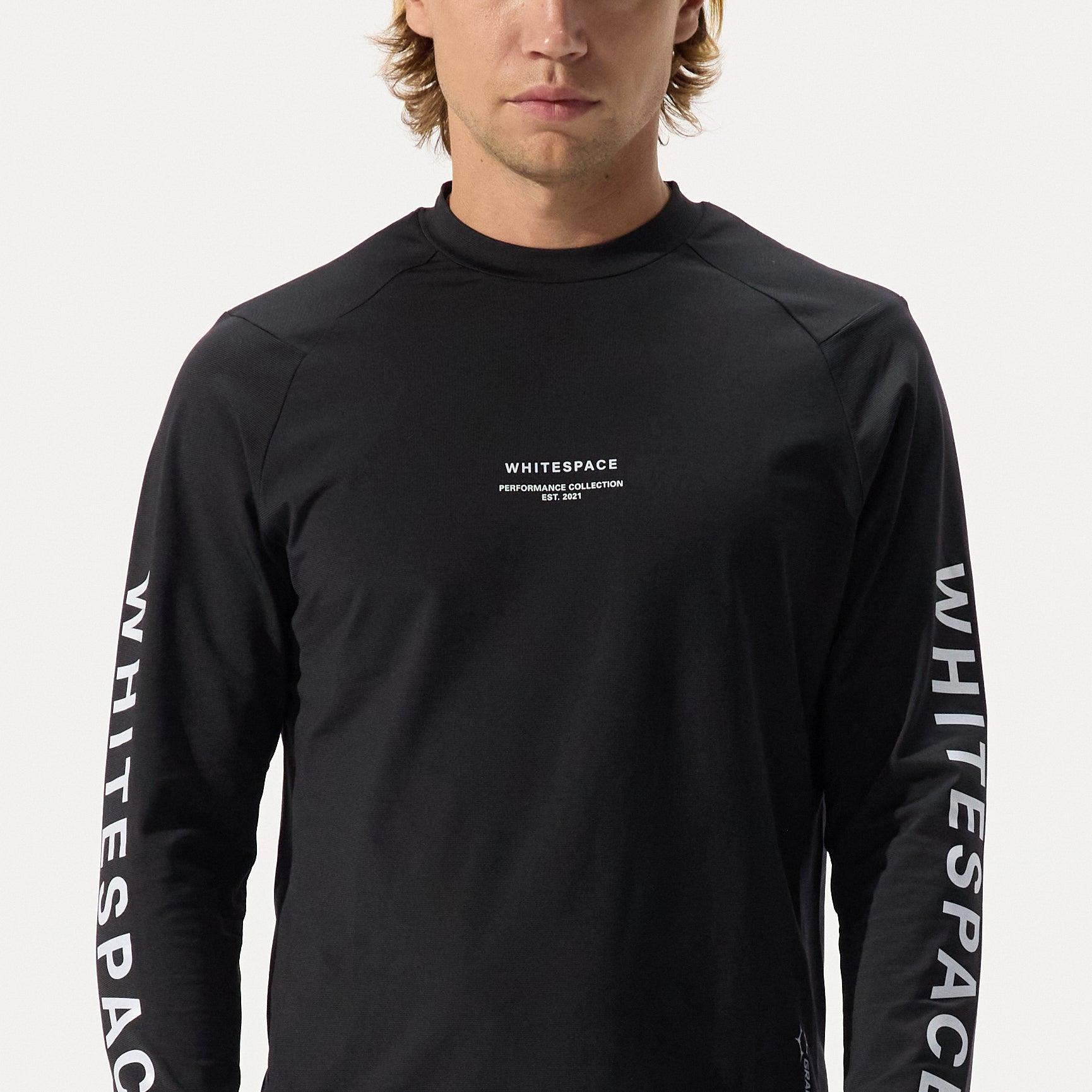 Model wearing graphine crewneck in black onyx featuring 'Whitespace' branding on a white background.