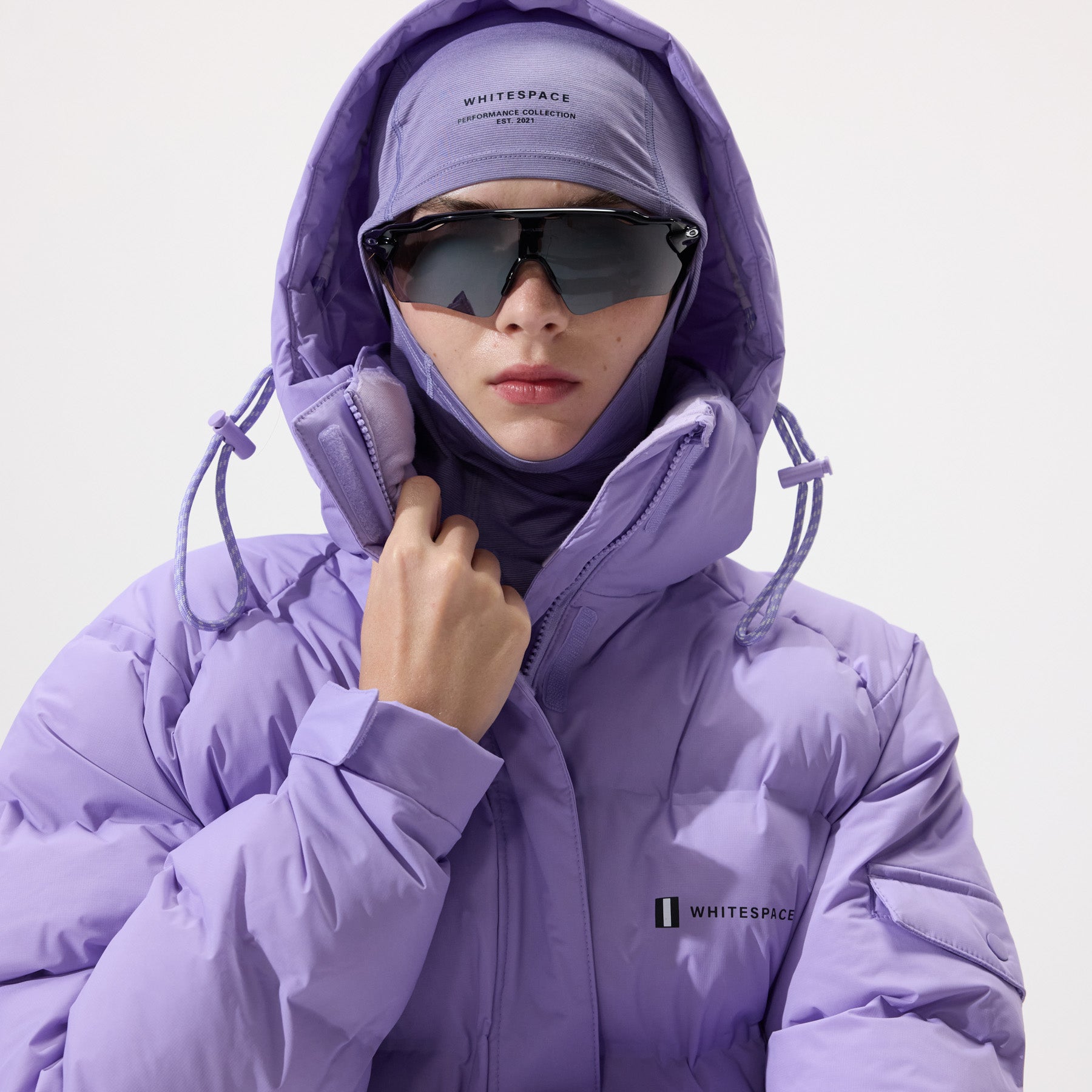 Model wearing a Insulated Parka Jacket in Sand Verbena and matching balaclava with 'Whitespace' branding on a white background.