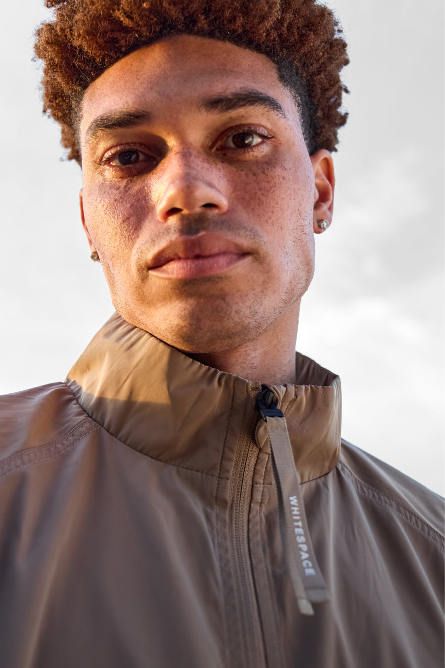 Model wearing the WHITESPACE Windbreaker Jacket in Desert Taupe.