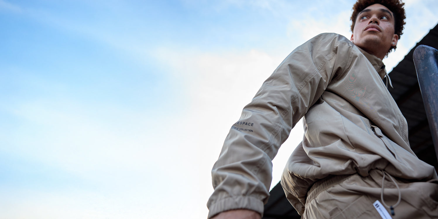 Model wearing the WHITESPACE Windbreaker Jacket and Volley Short in Desert Taupe.