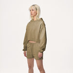 Model wearing WHITESPACE cropped hoodie in desert taupe and desert taupe sweatshorts, shown from the knees up, against a white background
