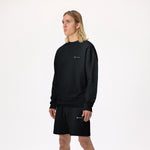 Model wearing WHITEPACE Fleece Crewneck in black with black fleece shorts shown from the knees up, against a white background.