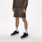 Model wearing WHITESPACE quarter zip sweatshirt in slate black/desert taupe and slate black fleece shorts with black shoes and white socks, shown from mid chest and down