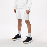 Model wearing WHITESPACE quarter zip sweatshirt in whisper white and whisper white fleece shorts with black shoes and white socks, shown from mid chest and down