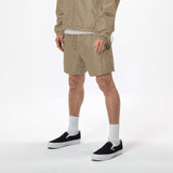 Model wearing WHITESPACE windbreaker in dessert taupe and desert taupe volley shorts with black shoes and white socks, shown from the chest down.