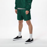 Model wearing WHITESPACE windbreaker jacket in rainforest green and rainforest green volley shorts with black shoes and white socks, shown from mid chest and down