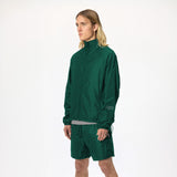 Model wearing WHITESPACE windbreaker in Rainforest green and matching shorts on a white background.
