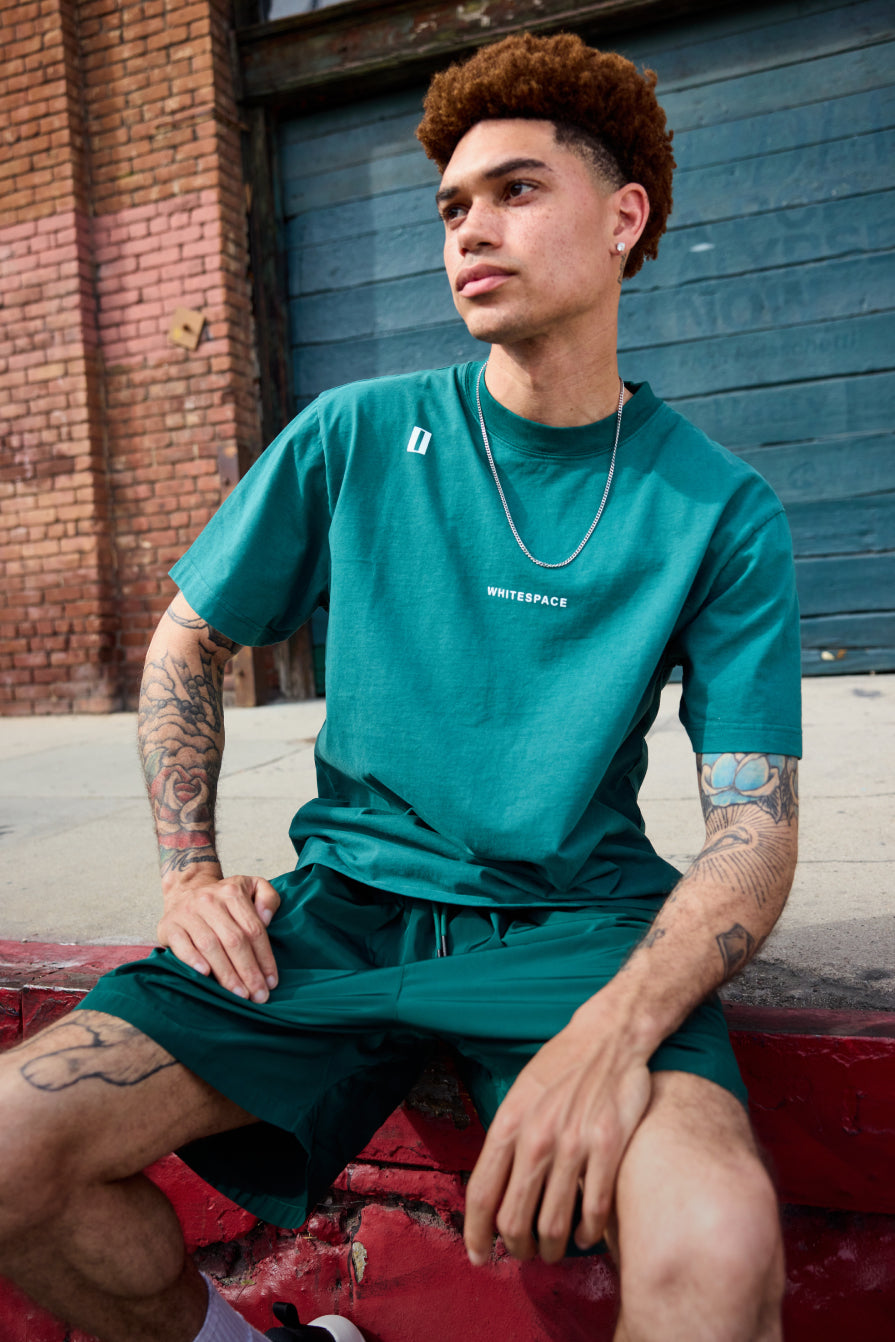 Model wearing the WHITESPACE Premium Graphic SS Tee in Rainforest