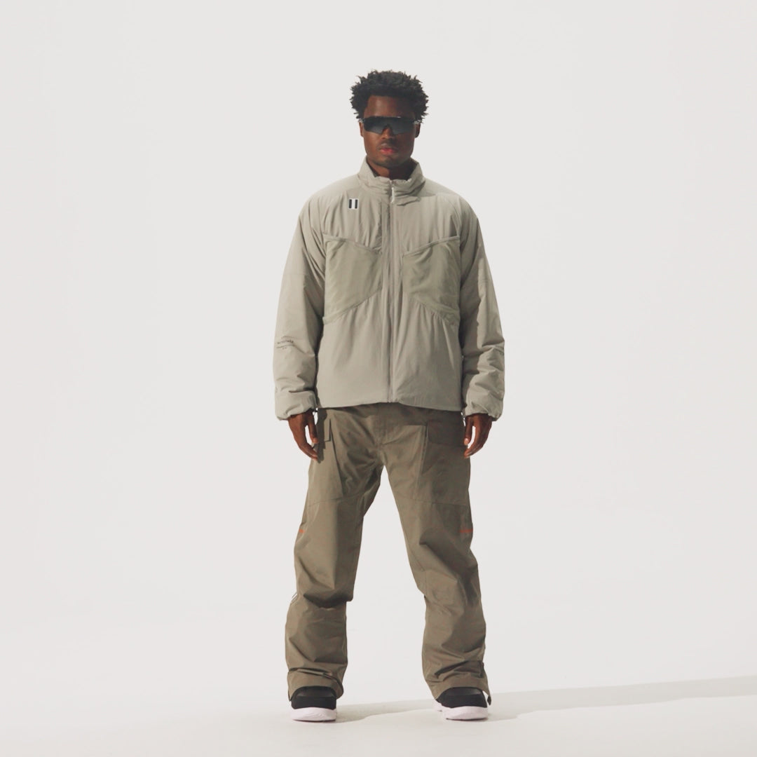 Video of model wearing Perfornance 3L Pant in Falcon color and a beige jacket and black sunglasses.