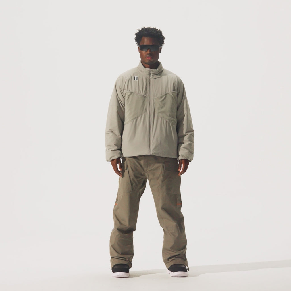 Video of model wearing Perfornance 3L Pant in Falcon color and a beige jacket and black sunglasses.
