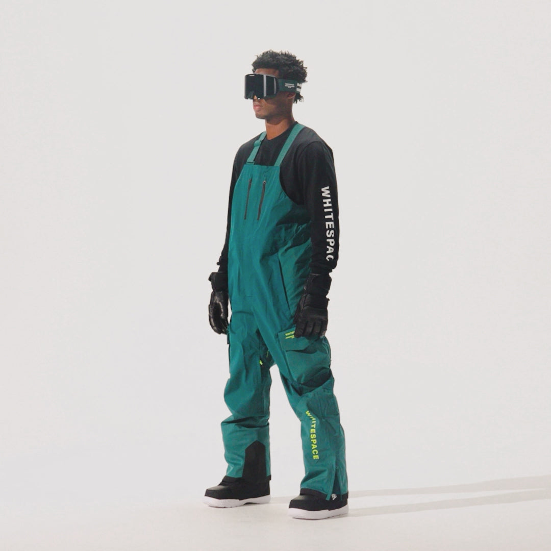 Model wearing snow pants and jacket in atlantic blue on a white background