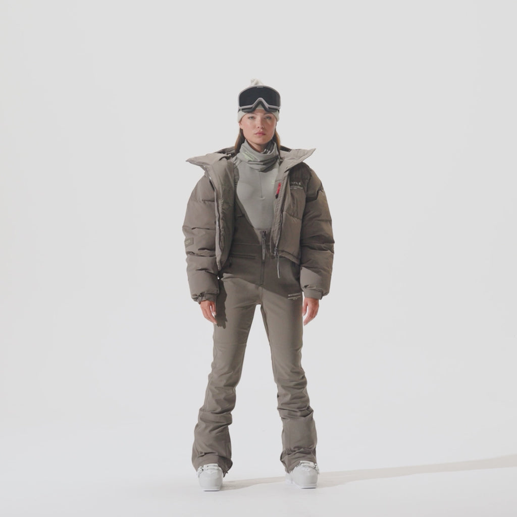 Video of model wearing Cropped Puffer Jacket in Falcon colorway with coordinating snow pants.