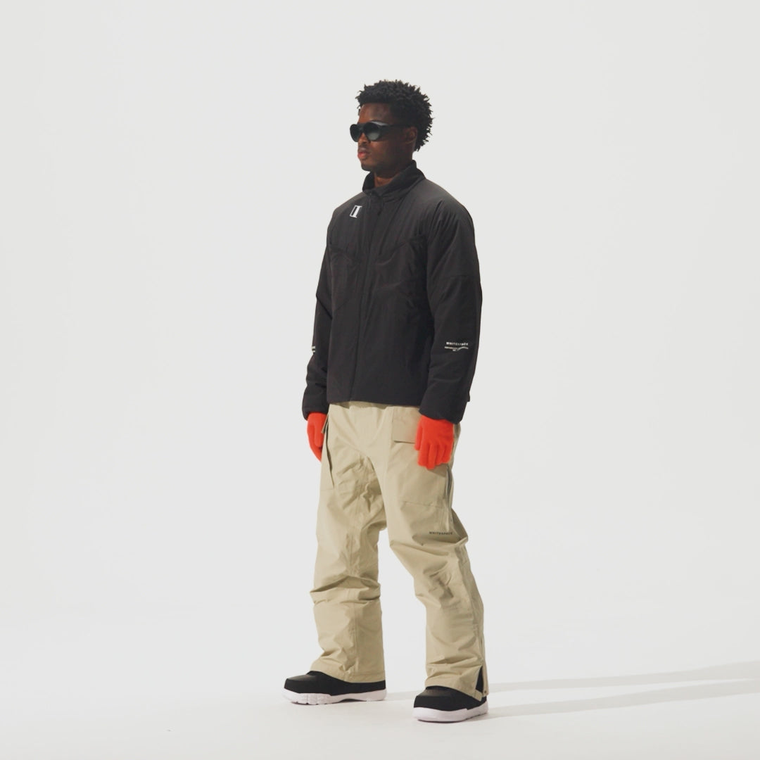 Video of model wearing Perfornance 3L Pant in Plaza Taupe color and a black jacket and orange gloves.